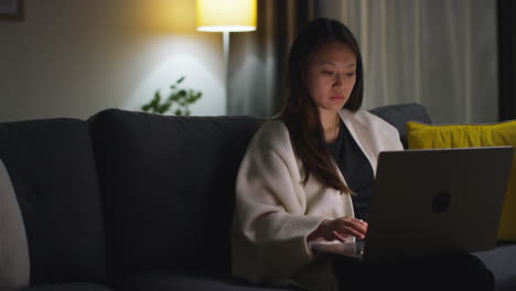Woman-Spending-Evening-At-Home-Sitting-On-Sofa-With-Laptop-Computer-Looking-At-Social-Media-Streaming-Or-Scrolling-Online-6